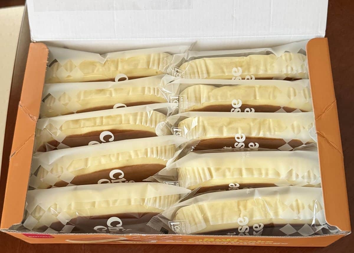 Image of the open box of soft cheesecake showing 10 individually wrapped cheesecakes in the box.