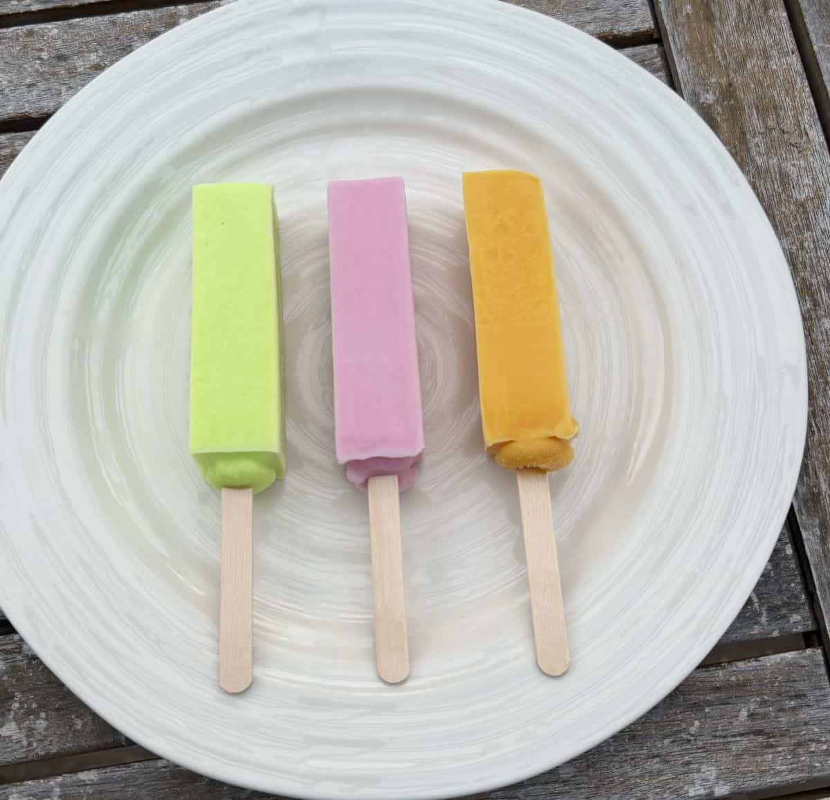 Image of a honeydew, strawberry and mango bar unwrapped and served on a white plate.