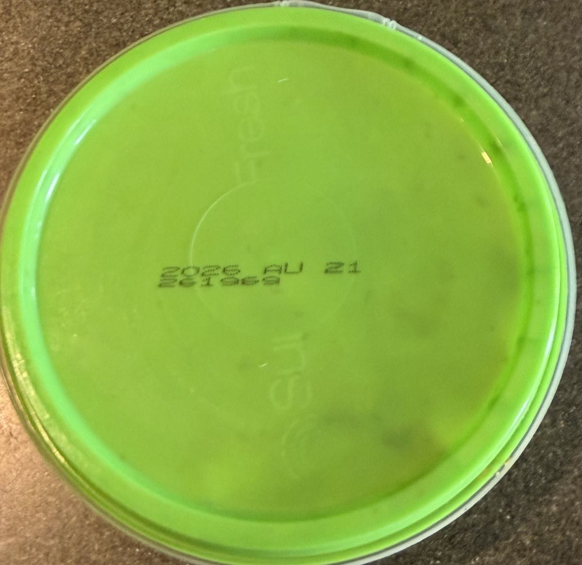 Top down image of orzo salad individual plastic round container on a table unopened.