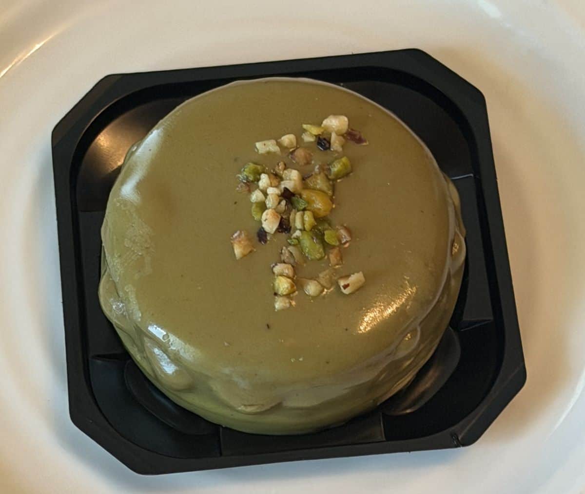Top down image of one chocolate mousse served on a white plate.