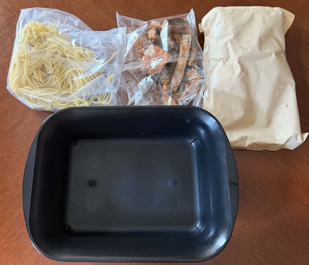 Image of everything that comes in the packaging of the Rana meal kit, unopened, sitting on a table.