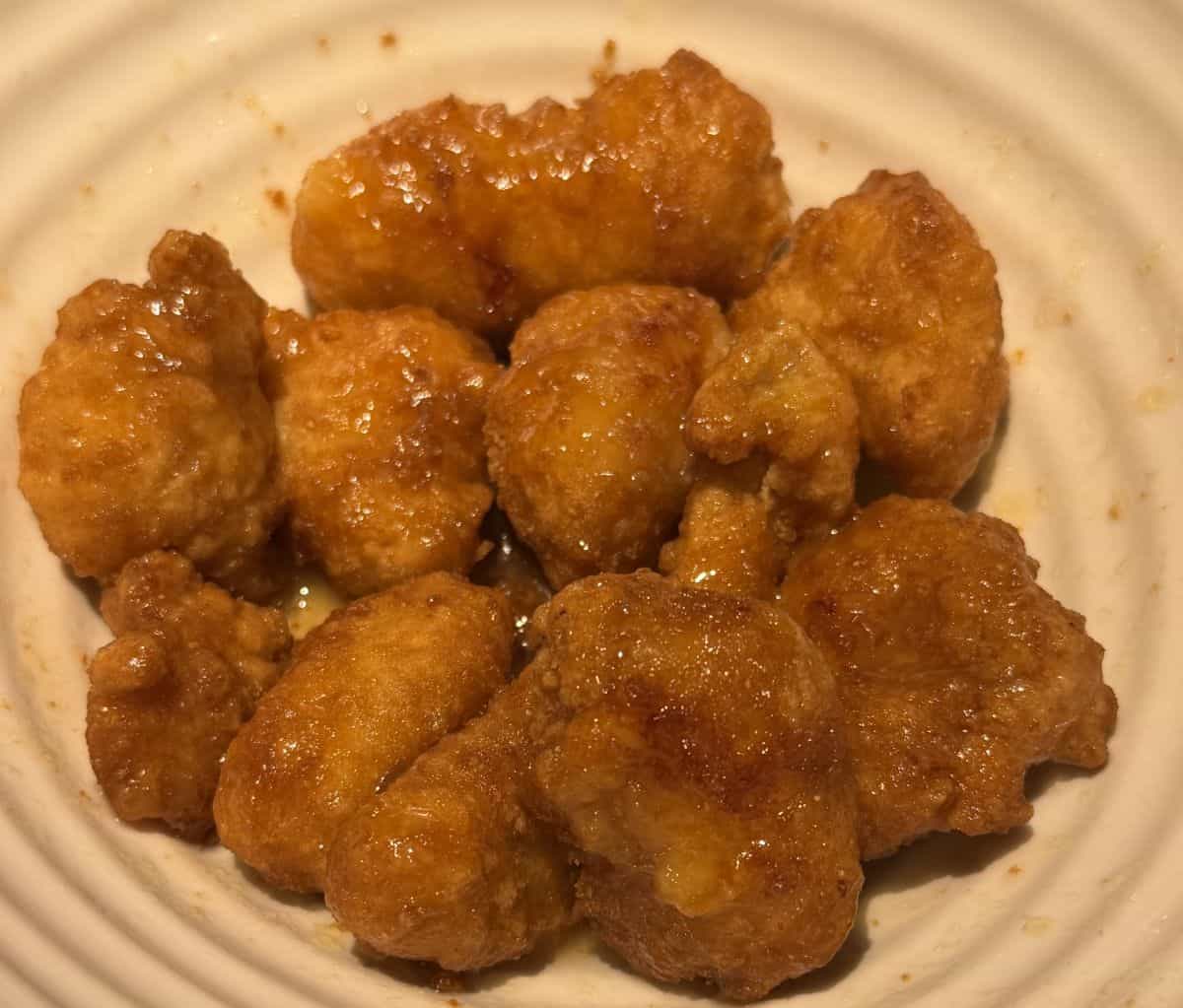 Top down image of the lemon chicken cooked and mixed with sauce in a bowl.
