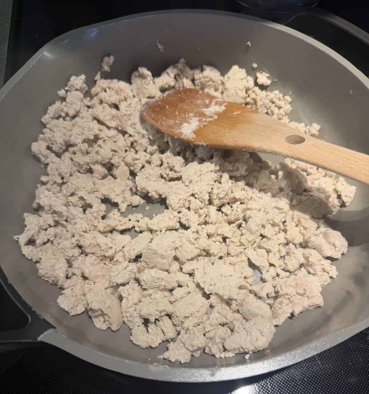 Top down image of cooked ground chicken in a pan.