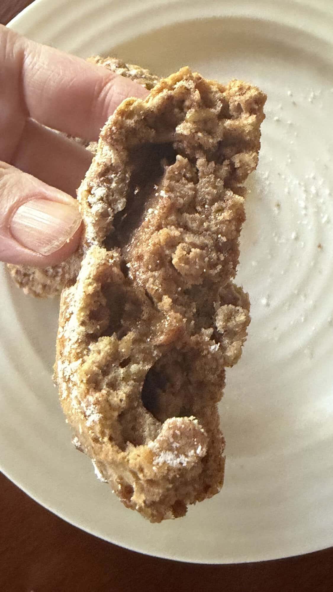 Image of a hand holding a scone that had some bites taken out of it so you can see the filling inside.