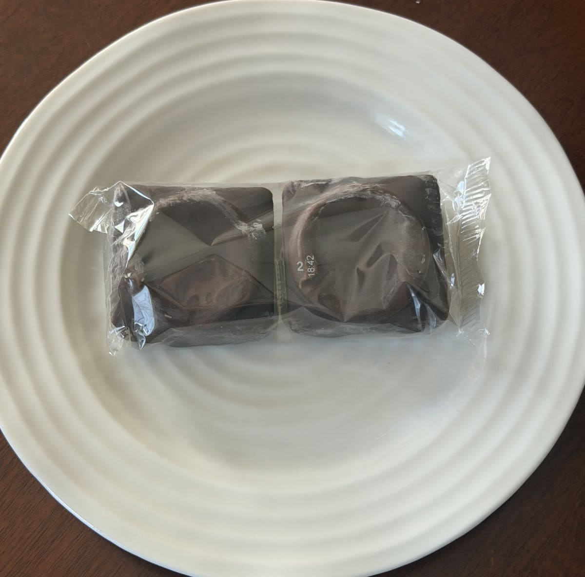 Image of two mini cakes in their packaging served on a white plate.