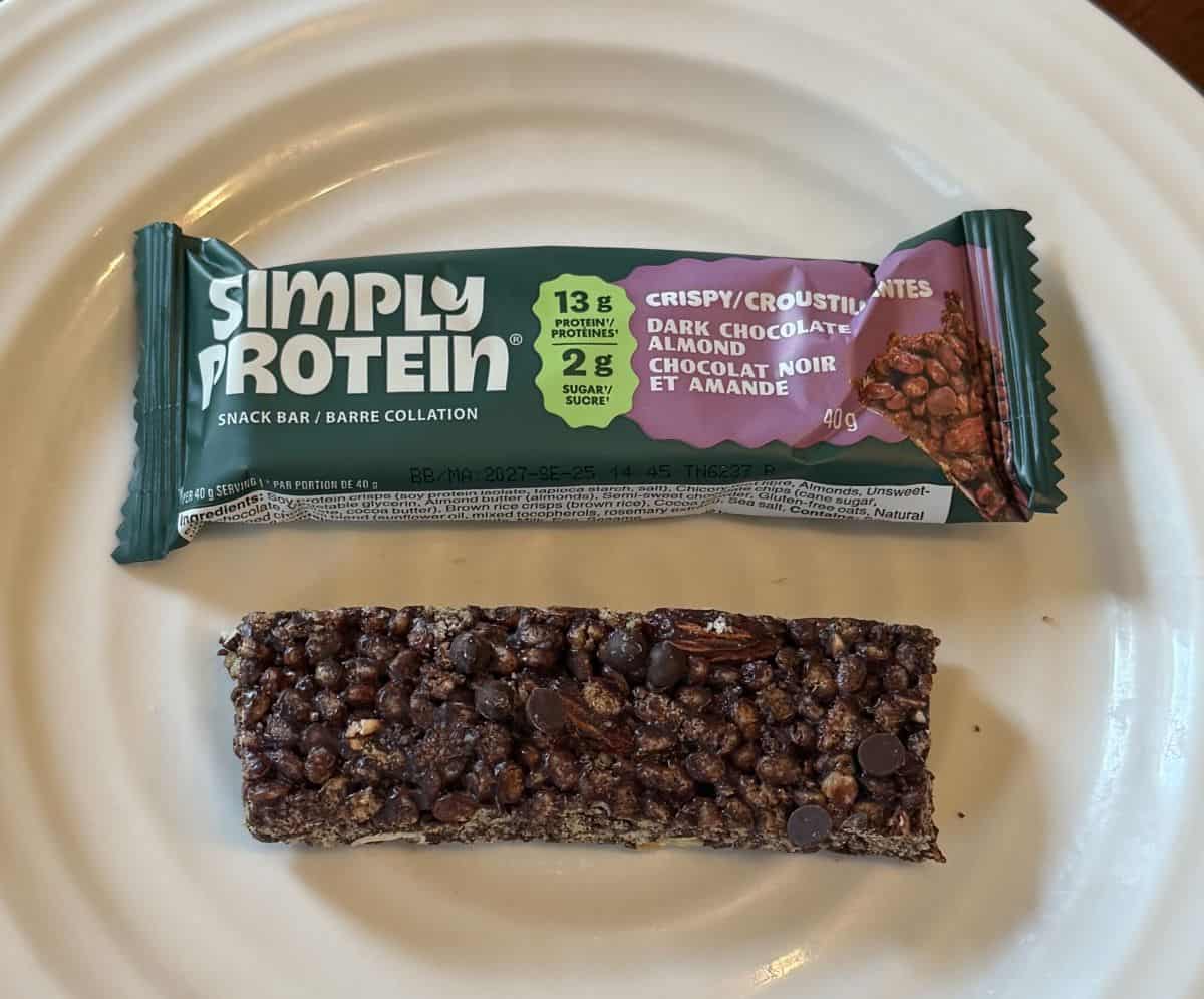 Image of one dark chocolate almond bar unwrapped and served on a white plate.