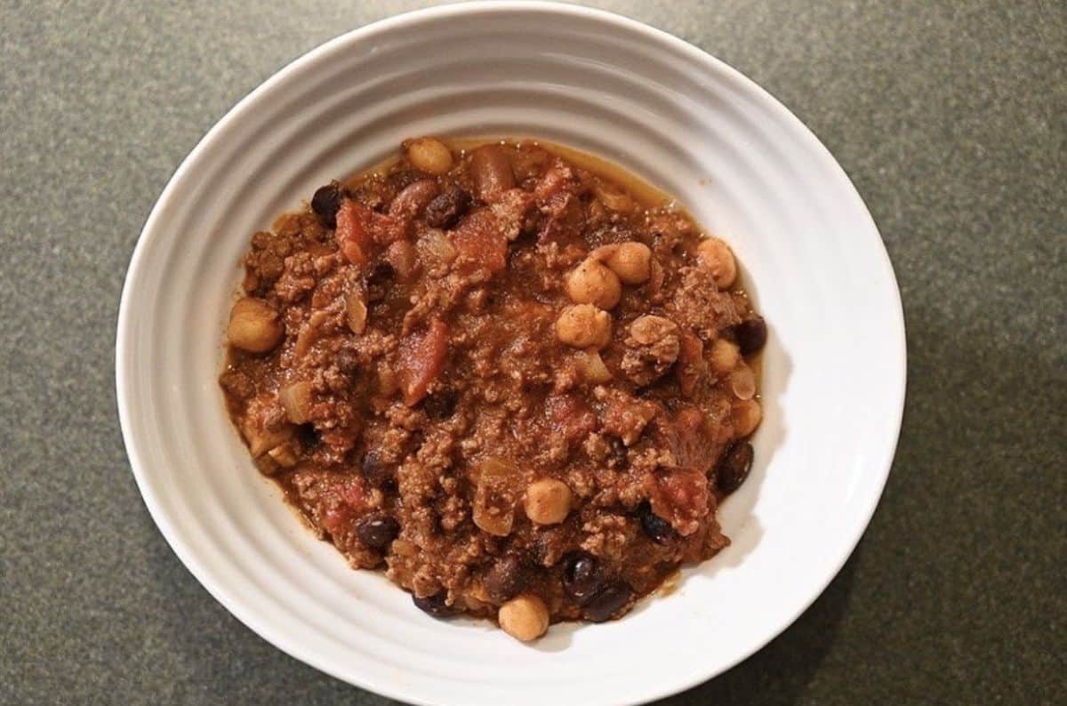 Top down image of a bowl of chili sitting on a counter.