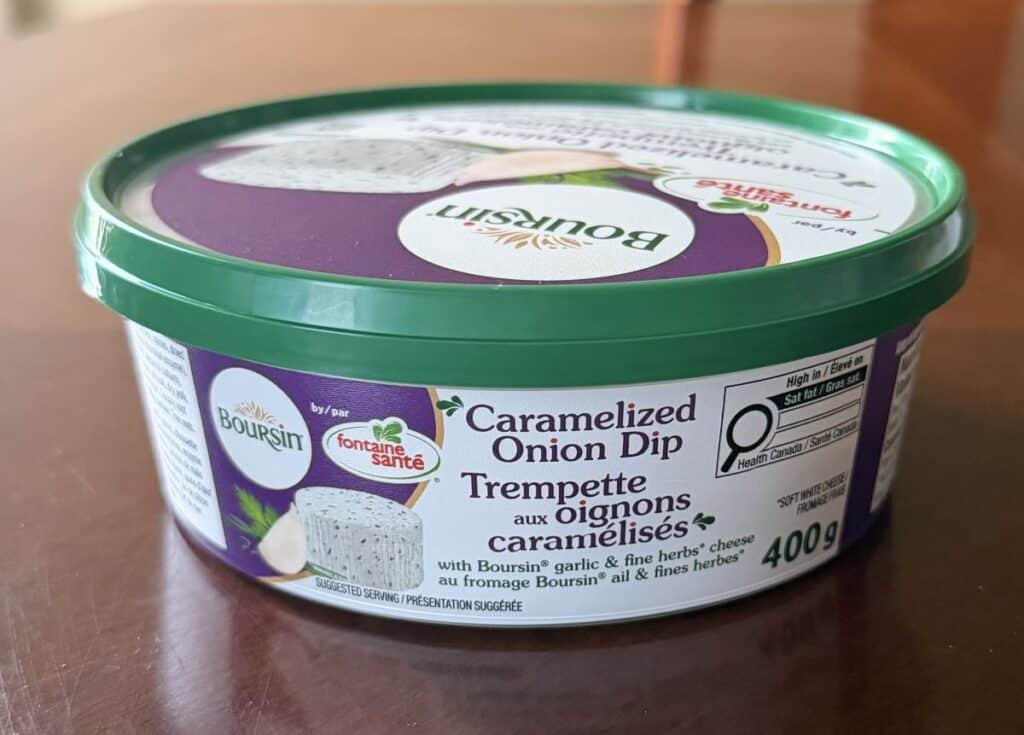 Image of a sealed tub of Costco Fontaine Sante Caramelized Onion Dip with Boursin sitting on a table.