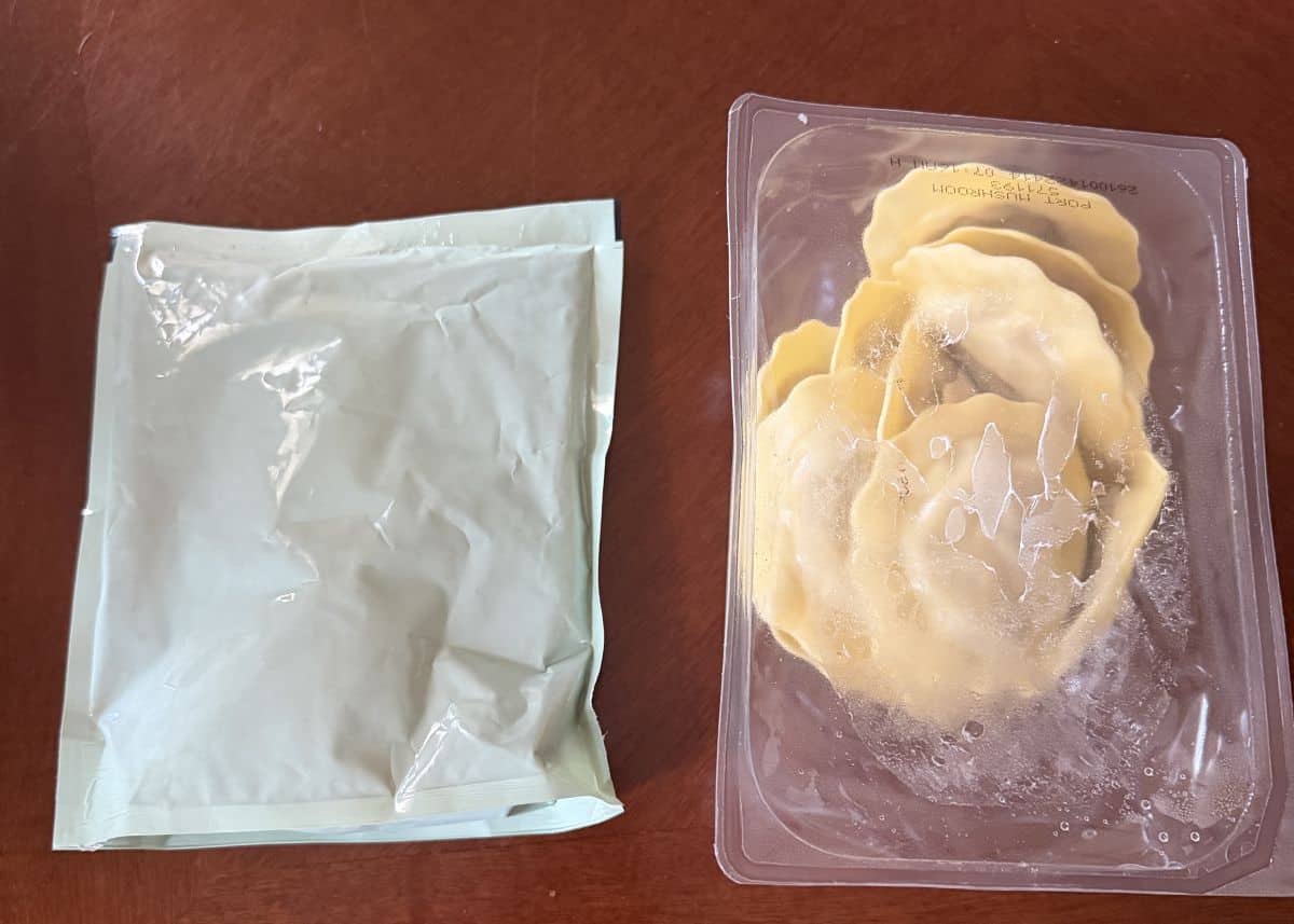 Image of an unopened package of sauce beside an unopened package of ravioli on a table.