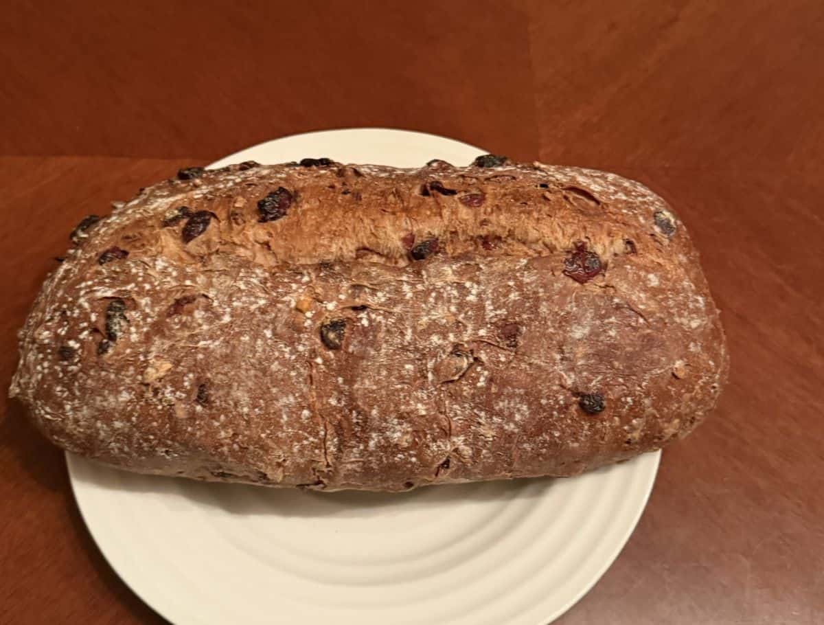 Image of the entire loaf served on a white plate before slicing it.