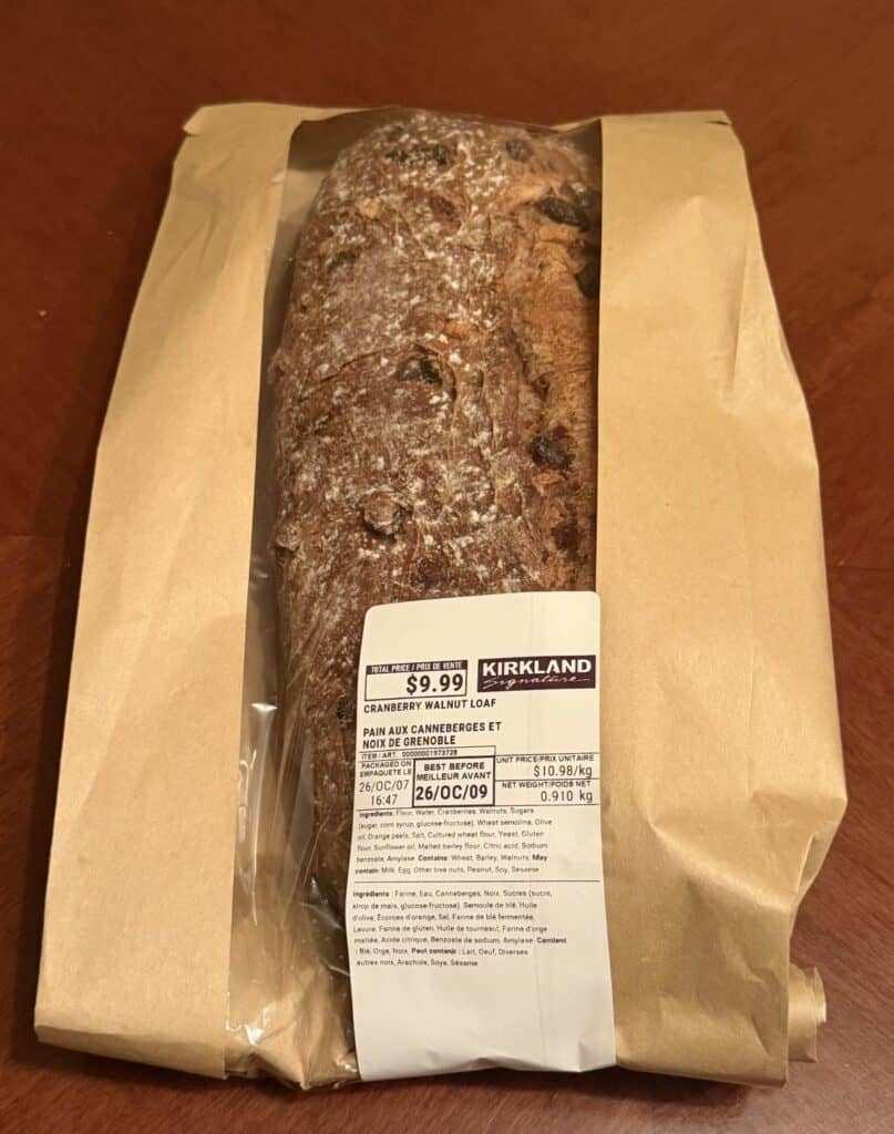 Image of the Costco Kirkland Signature Cranberry Walnut Loaf in its packaging unopened sitting on a table.